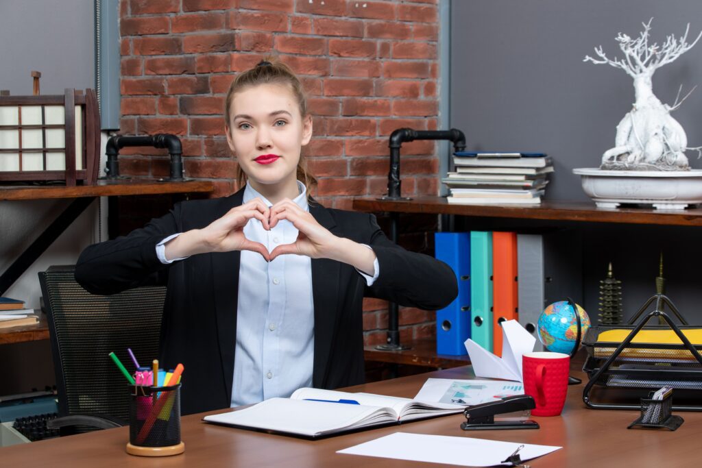 A woman with a study table and books after following the top 25 best-kept secrets. She looks very happy.